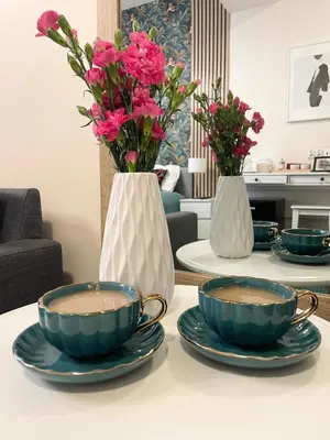 two vases with plates and flowers on a table at Gertrudy 10 Residence - 1-Minute Walk to the Old Town in Kraków
