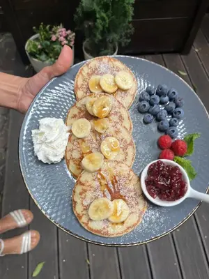 a plate of pancakes with bananas and fruit on it at Gertrudy 10 Residence - 1-Minute Walk to the Old Town in Kraków