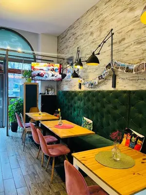 a restaurant with wooden tables and green booths at Gertrudy 10 Residence - 1-Minute Walk to the Old Town in Kraków