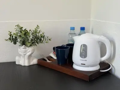 a coffee maker on a wooden tray with bottles of water at IRIS Aparthotel in Kraków