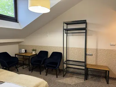 a room with two beds and a table and chairs at IRIS Aparthotel in Kraków