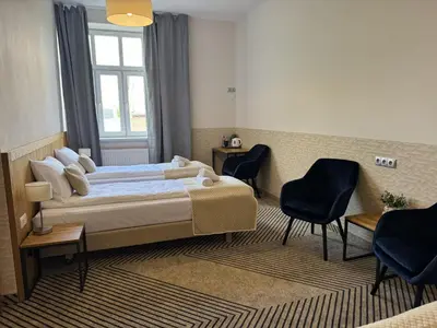 a hotel room with a bed and two chairs at IRIS Aparthotel in Kraków
