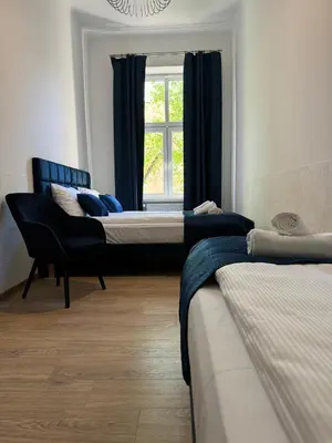 a room with three beds and a window at IRIS Aparthotel in Kraków