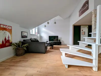 a living room with a couch and a stair case at Starowiślna 34 by Homeprime in Kraków