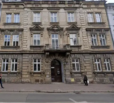 an old stone building with people walking in front of it at Starowiślna 34 by Homeprime in Kraków