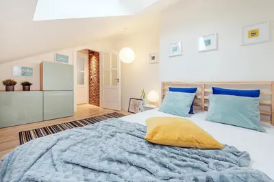 a bedroom with a large bed with blue pillows at Starowiślna 34 by Homeprime in Kraków