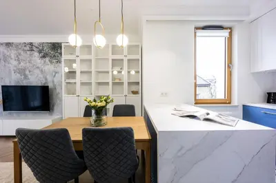 a kitchen with a table with chairs and a tv at Native Apartments Orawska 14/127 in Kraków