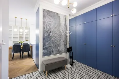 a living room with blue cabinets and a table at Native Apartments Orawska 14/127 in Kraków