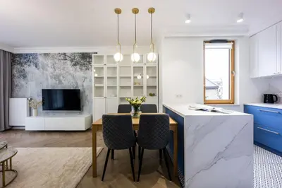 a kitchen and dining room with a table and chairs at Native Apartments Orawska 14/127 in Kraków