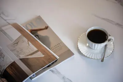 a book and a cup of coffee on a table at Native Apartments Orawska 14/127 in Kraków