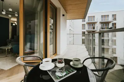 a black table and chairs on a balcony at Native Apartments Orawska 14/127 in Kraków