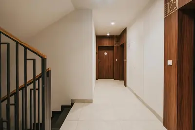 an empty hallway with stairs and a door at Native Apartments Orawska 14/127 in Kraków