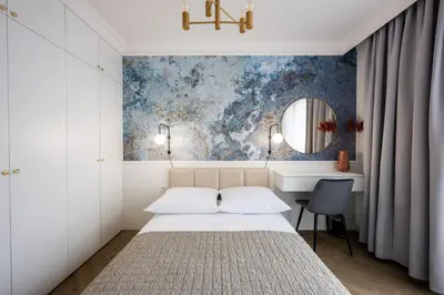 a bedroom with a bed and a desk and a mirror at Native Apartments Orawska 14/127 in Kraków