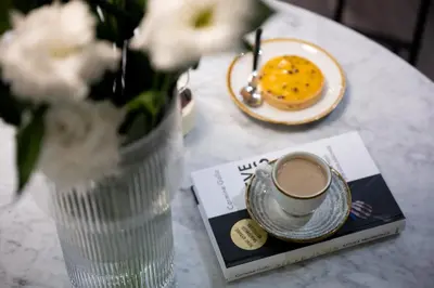 a table with a cup of coffee and a plate of food at Native Apartments Kościuszki 39/22 in Kraków