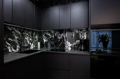 a kitchen with black cabinets and a sink at Native Apartments Kościuszki 39/22 in Kraków