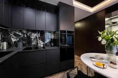 a kitchen with black cabinets and a table at Native Apartments Kościuszki 39/22 in Kraków