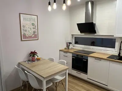 a kitchen with a wooden table and a small table and chairs at Cosy 3 room apartment close to Main Square in Kraków