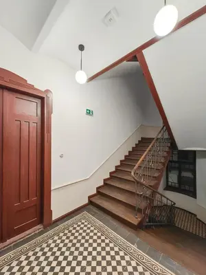 a staircase in a building with a door and a checkered floor at D21 Art Loft Apartment in Kraków