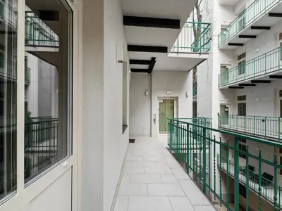 an empty hallway of an apartment building with balconies at D21 Art Loft Apartment in Kraków