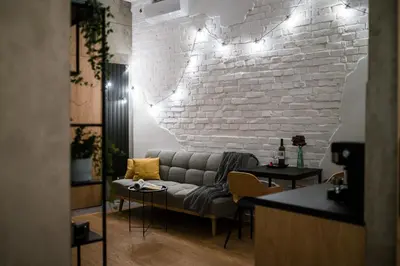 a living room with a couch and a white brick wall at D21 Art Loft Apartment in Kraków