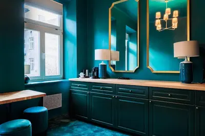 a bathroom with blue walls and a vanity with mirrors at Green Gertrudy in Kraków