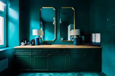 a bathroom with blue walls and a sink with a mirror at Green Gertrudy in Kraków