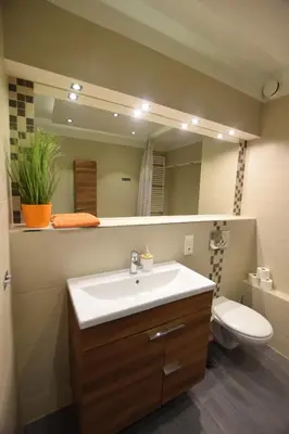 a bathroom with a sink and a toilet and a mirror at Apartament z podziemnym parkingiem ulica Wroclawska in Kraków