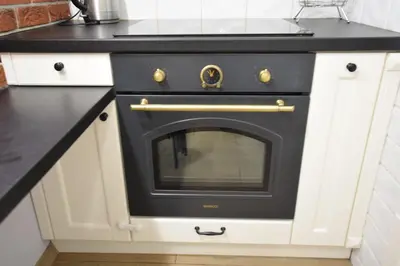 a black oven in a kitchen with white cabinets at Apartament z podziemnym parkingiem ulica Wroclawska in Kraków