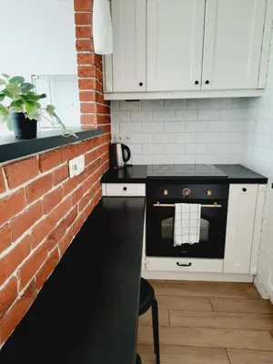 a kitchen with a brick wall and an oven at Apartament z podziemnym parkingiem ulica Wroclawska in Kraków