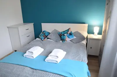 a blue bedroom with a bed with towels on it at Apartament z podziemnym parkingiem ulica Wroclawska in Kraków