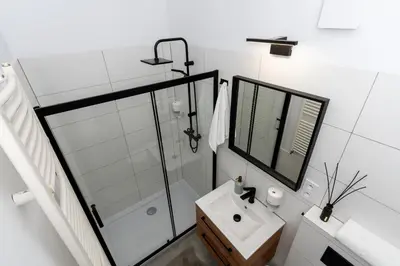 a white bathroom with a shower and a sink at Cracow Best Location Apartment No:6 by Cozyplace in Kraków