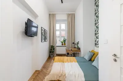 a small room with a bed and a tv at Cracow Best Location Apartment No:6 by Cozyplace in Kraków