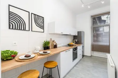 a kitchen with white appliances and wooden countertops at Cracow Best Location Apartment No:6 by Cozyplace in Kraków