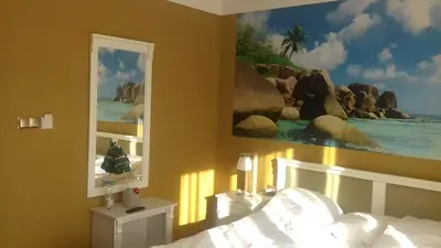 a bedroom with a bed and a painting on the wall at Hotel Karolek in Zawoja