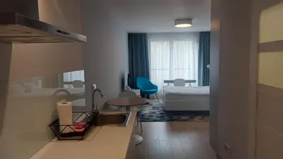 a bathroom with a sink and a bedroom with a bed at Kazimierz Center Apartments Halicka 5 in Kraków