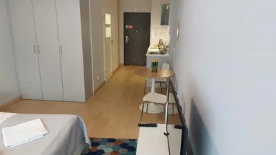 a room with a bed and a table and a kitchen at Kazimierz Center Apartments Halicka 5 in Kraków