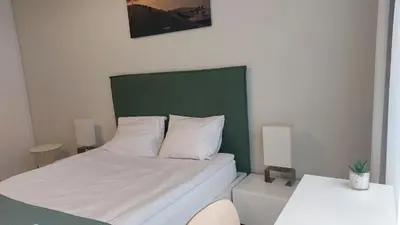a bed with a green headboard in a room at Kazimierz Center Apartments Halicka 5 in Kraków