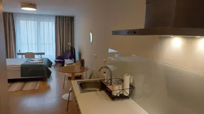 a kitchen with a sink and a room with a bed at Kazimierz Center Apartments Halicka 5 in Kraków