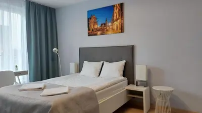 a bedroom with a bed with a picture on the wall at Kazimierz Center Apartments Halicka 5 in Kraków