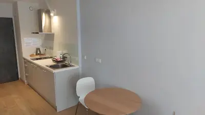 a small kitchen with a table and a sink at Kazimierz Center Apartments Halicka 5 in Kraków