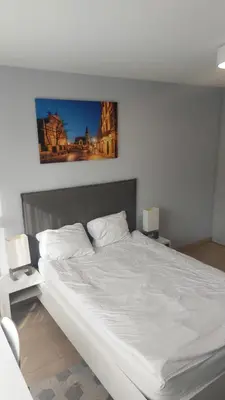 a bedroom with a large white bed with two lamps at Kazimierz Center Apartments Halicka 5 in Kraków