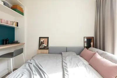 a small bedroom with a bed with pink pillows at MILESTONE Krakow Center Student Living by Tribera in Kraków