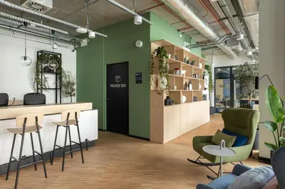 an office with green walls and chairs and a counter at MILESTONE Krakow Center Student Living by Tribera in Kraków