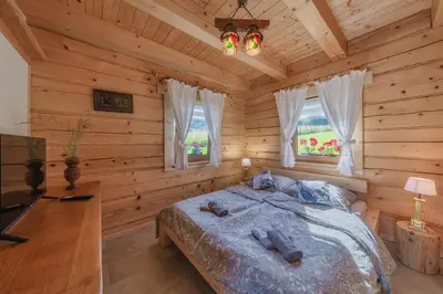 a bedroom with a bed in a log cabin at Leśny Zakątek Jurków in Jurków