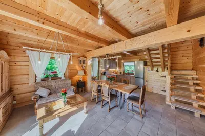 a dining room and kitchen in a log cabin at Leśny Zakątek Jurków in Jurków
