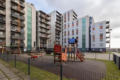 an empty playground in front of tall buildings at Modern Apartment with Parking in Cracow by Rent like home in Kraków