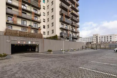 an empty parking lot in front of a building at Modern Apartment with Parking in Cracow by Rent like home in Kraków