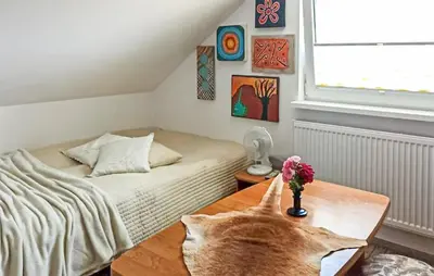 a cat sitting on a table in a bedroom at Pet Friendly Apartment In Spytkowice in Spytkowice