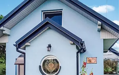 a blue house with a round window and a lamp at Pet Friendly Apartment In Spytkowice in Spytkowice