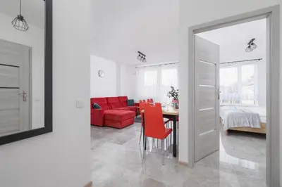a living room with a red couch and a table at Kraków Elegant Apartment Near The Water Park by Rent like home in Kraków
